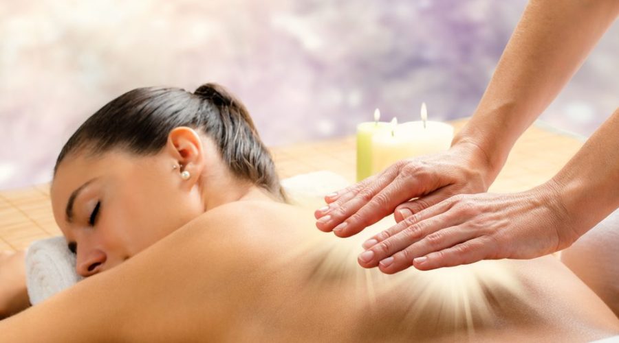 A close-up of a person receiving a massage with calming candles in the background.